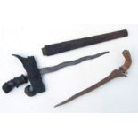 An Indonesian Kris with carved hardwood handle and scabbard and wavy steel blade, 57cms long;