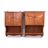 A pair of Art Deco walnut wall cupboards, the pair of doors inlaid with dancing ladies above a