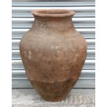 A large terracotta olive jar with banded and wavy decoration, 57cms high.Condition Reportwell