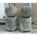 A pair of well weathered granite spheres on stands. 71cm highCondition ReportThe spheres are