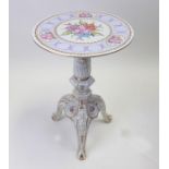 A Dresden porcelain tripod table decorated with flowers and gilt highlights, 46cms diameter.