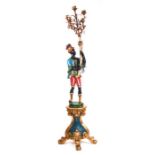 A floor standing painted and gilded Blackamore figure on stand holding a gilt metal five-branch