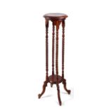 A mahogany plant stand on four barleytwist columns.