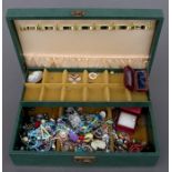 A quantity of costume jewellery to include pendants & brooches in a green jewellery box.