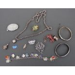 A quantity of silver and white metal jewellery to include a charm bracelet with enamel charms.