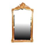 A late 19th / early 20th century gilt pier mirror with foliate scrolled frame enclosing a modern