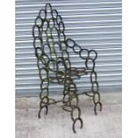 A large cast iron garden chair made from horseshoes, 56cms wide.