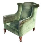 An Edwardian upholstered wing back armchair on dwarf cabriole front supports.