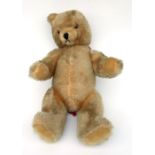 A large vintage plush jointed teddy bear with internal growler, 64cms high.