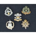 Five plated Military cap badges: The Devonshire Regiment, The Suffolk Regiment, The East