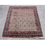 A Persian Seraband rug with repeat central design within floral borders on a cream ground, 205 by
