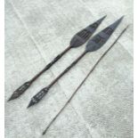 A pair of African paddle spears, 171cms high; together with a fishing spear with barbed tip (3).