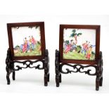 A pair of Chinese miniature enamel panels decorated with figures in a landscape, in hardwood