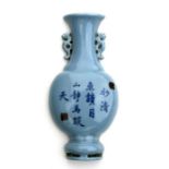 A Chinese half vase wall pocket decorated with calligraphy on a pale blue ground, 20cms high.