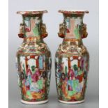 A pair of Chinese Canton famille rose vases decorated with figures and birds, with applied