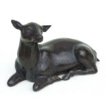 A large bronzed metal model of a recumbent deer fawn, 28.5 cms (11.25 ins) long.