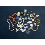 A quantity of costume jewellery to include a coral branch necklace, brooches and earrings.