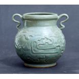 A Celadon glazed two-handled vase with archaic style decoration (possibly Korean), 15cms (6ins)