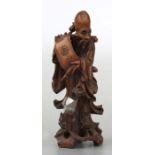 A Chinese root wood figure depicting Shoulau holding a scroll, 21cms high.