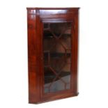 A George III style mahogany hanging corner cabinet with single astragal glazed panelled door
