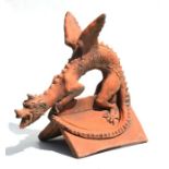 A terracotta ridge tile depicting a dragon figure, approx 45cms wide.