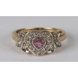 A 9ct gold dress ring set with a central heart shaped pink stone surrounded by diamonds, approx UK