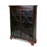 An Edwardian mahogany bookcase, the pair of astragal glazed doors enclosing a shelved interior, on