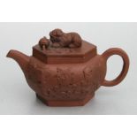 A Chinese Yixing teapot decorated in relief with temple lions and temple lion finial, 12cms high.