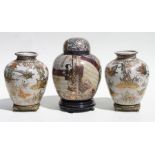 A pair of Satsuma baluster vases decorated with butterflies within flowering foliage, each 24cms