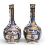 A pair of Chinese clobbered bottle vases decorated with exotic birds, foliage and blue & white