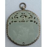 A Chinese white metal mounted pierced jade pendant decorated with a robed figure beneath a pair of