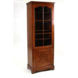 A figured walnut display case, the single glazed door enclosing a shelved interior with cupboard