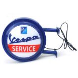 A contemporary Vespa service double-sided circular wall mounted advertising illuminated sign,