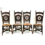 A set of four carved oak Brittany dining chairs, the back rails carved with birds, with rush seats