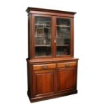 A 19th century walnut glazed bookcase on cupboard, the upper section with twin glazed panelled doors