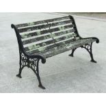 A well weathered garden bench with cast iron ends, 126cms wide.