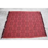 An Indian throw with repeated medallion design on a red ground, 140 by 170cms.