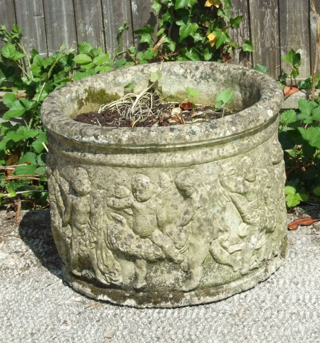 A reconstituted stone garden planter of cylindrical form, decorated with figures, 46cms diameter.