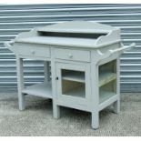 A painted washstand with three quarter gallery above two frieze drawers and glazed panelled door