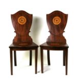 A pair of reproduction mahogany hall chairs with shield shaped back and solid seat, both inlaid with