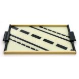 An Art Deco black and cream wooden framed serving tray with glass insert, 46 by 31 cms (18 by 12