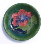 A William Moorcroft Hibiscus pattern shallow dish, impressed 'Moorcroft' to the base and signed,