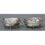 A pair of modern George III style silver bonbon dishes with pierced decoration and shell capped hoof