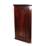 A 19th century mahogany hanging corner cabinet with single panelled door enclosing a shelved