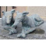 A pair of bronzed reconstituted figures of recumbent whippets, each approx 65cms long (2).