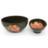 A William Moorcroft Hibiscus pattern bowl, 17cms wide; together with a similar footed bowl, 11cms