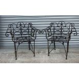 A pair of wrought iron garden chairs with scroll arms (2).