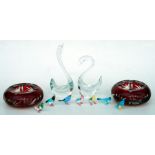 A pair of red cased glass ashtrays, 16cms diameter; together with a pair of Art glass figural swans,