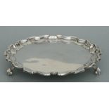 A silver card tray with shaped border, on three legs, London 1918, weight 327g, 21cms diameter.