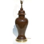 A large pottery baluster form brown glazed table lamp, 54cms high.